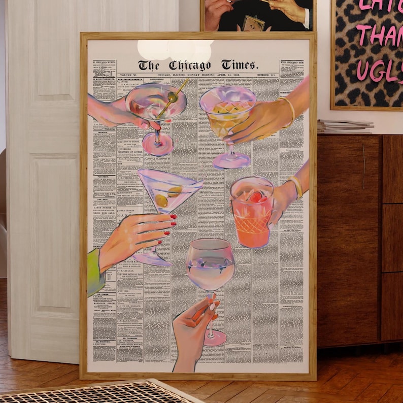K&ouml;nnte beinhalten: Gerahmter Kunstdruck mit Cocktailgl&auml;sern, die von H&auml;nden gehalten werden, vor einem Hintergrund aus einer alten Zeitung. Der Druck enth&auml;lt den Text "The Chicago Times" oben. Die Cocktails sind in verschiedenen Farben.