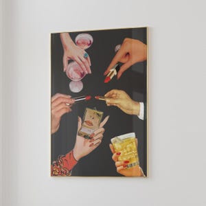 Peut inclure: Impression artistique encadr&eacute;e pr&eacute;sentant un collage de mains tenant du rouge &agrave; l&egrave;vres, des cocktails et un miroir compact. Les mains sont orn&eacute;es de bagues et de vernis &agrave; ongles. Le fond est noir, et le cadre est dor&eacute;.