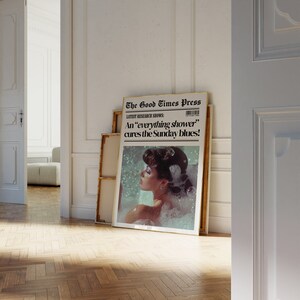May include: A framed print of a vintage newspaper article with the headline "The Good Times Press" and the subheading "LATEST RESEARCH SHOWS: An "everything shower" cures the Sunday blues!" The image shows a woman in a bathtub with bubbles.