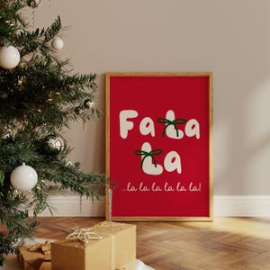 May include: A framed print with a red background and white text that says "Fa la la la la la!" with green bows on the letters.