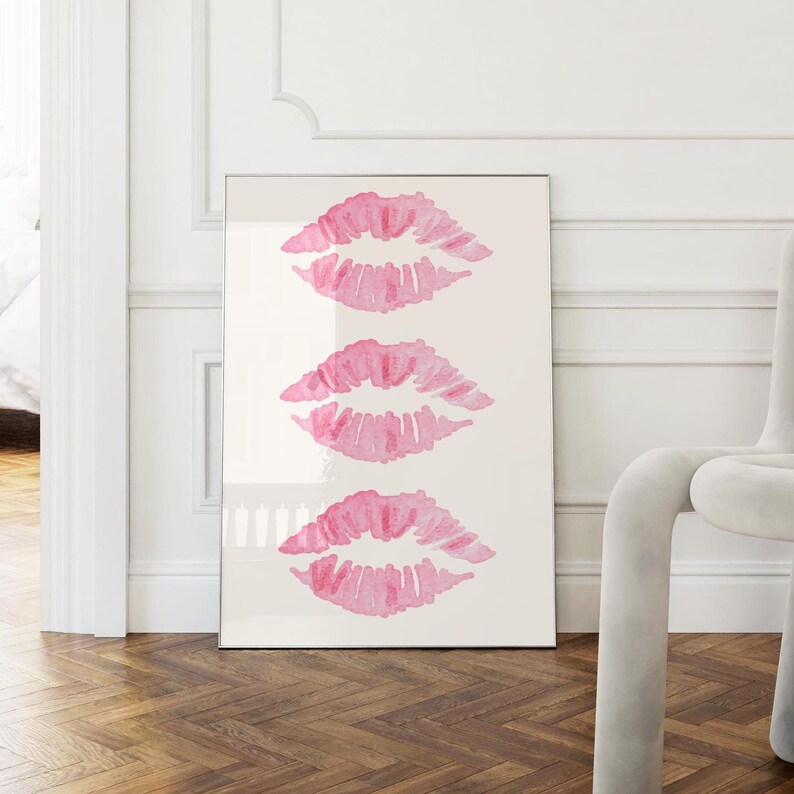 May include: A white poster with three pink watercolor lip prints in a vertical row.
