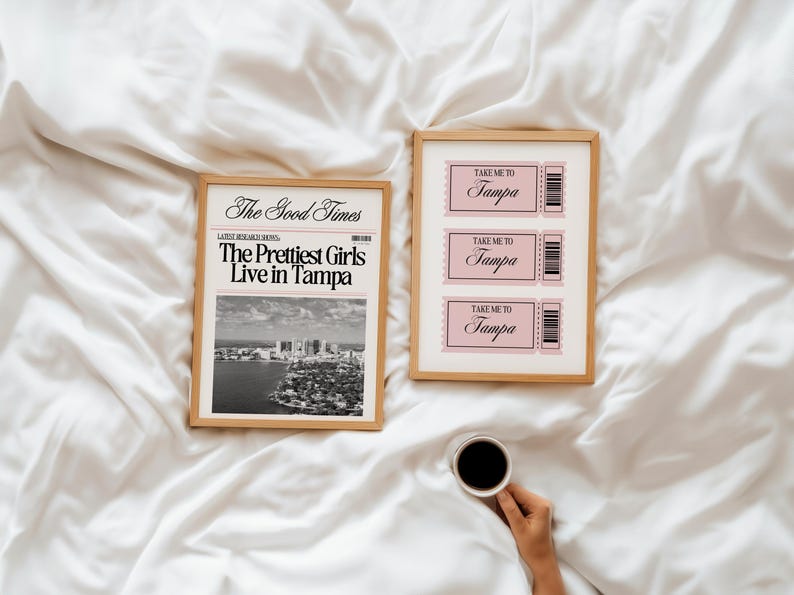 Może przedstawiać: Dwa oprawione wydruki na białej powierzchni. Jeden zawiera tekst "The Good Times" i "The Prettiest Girls Live in Tampa" nad czarno-białą panoramą miasta. Drugi ma trzy r&oacute;żowe bilety z napisem "Take Me To Tampa".