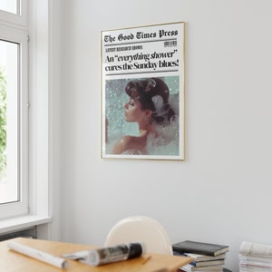 May include: A vintage newspaper print with a gold frame, featuring a woman in a bubble bath with the headline "The Good Times Press" and the text "LATEST RESEARCH SHOWS: An 'everything shower' cures the Sunday blues!"