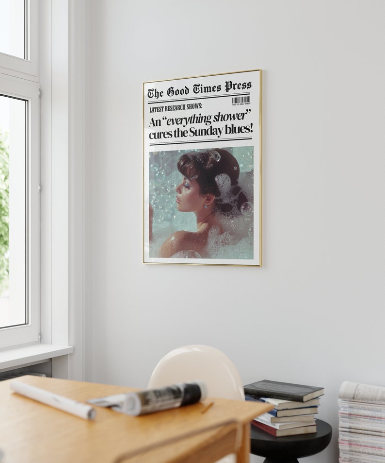 May include: A vintage newspaper print with a gold frame, featuring a woman in a bubble bath with the headline "The Good Times Press" and the text "LATEST RESEARCH SHOWS: An 'everything shower' cures the Sunday blues!"