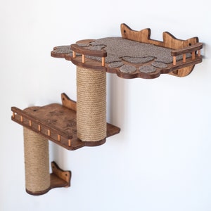 Peut inclure: Étagère pour chat à deux niveaux en bois, conçue pour être fixée au mur. L'étagère supérieure a une forme de patte avec une surface recouverte de moquette. L'étagère inférieure est rectangulaire. Les deux étagères ont des poteaux à gratter en corde de sisal.