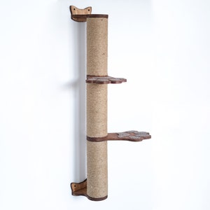 May include: A wall-mounted cat tree with a sisal-covered scratching post and two platforms. The platforms are shaped like paw prints and are covered in brown fabric.