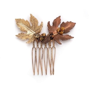 Op de afbeelding: Haar kam met gouden en koperen bladeren met bruine glazen kralen. De kam heeft zeven tanden.