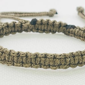 May include: A brown braided rope bracelet with adjustable closure.