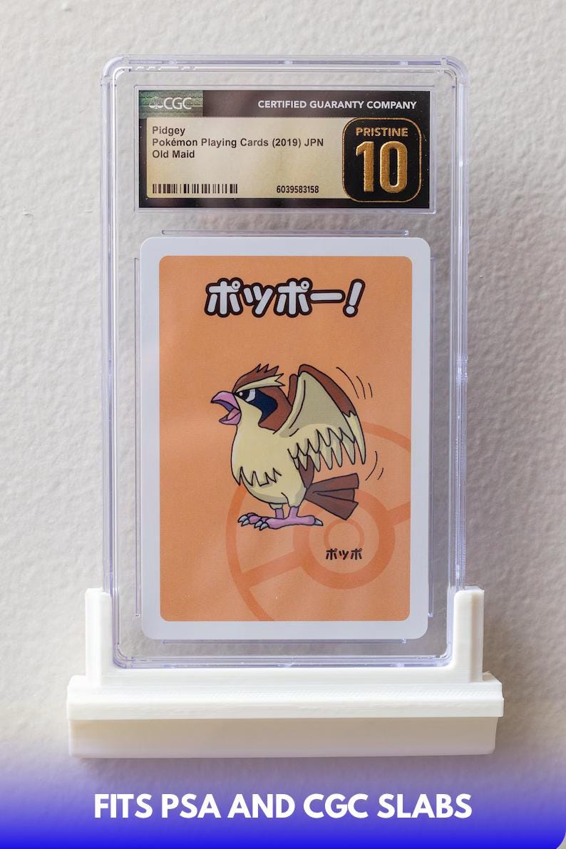 Puede incluir: Una carta Pok&eacute;mon Pidgey calificada del set japon&eacute;s Old Maid de 2019, encerrada en un soporte protector transparente. La tarjeta presenta una ilustraci&oacute;n de dibujos animados de una criatura parecida a un p&aacute;jaro. El soporte est&aacute; calificado como Pristine 10 por CGC.