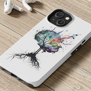 Könnte beinhalten: Eine weiße Handyhülle mit einem farbenfrohen Aquarell-Baumdesign. Der Baum hat einen schwarzen Stamm und Wurzeln und ist von Farbspritzern umgeben.