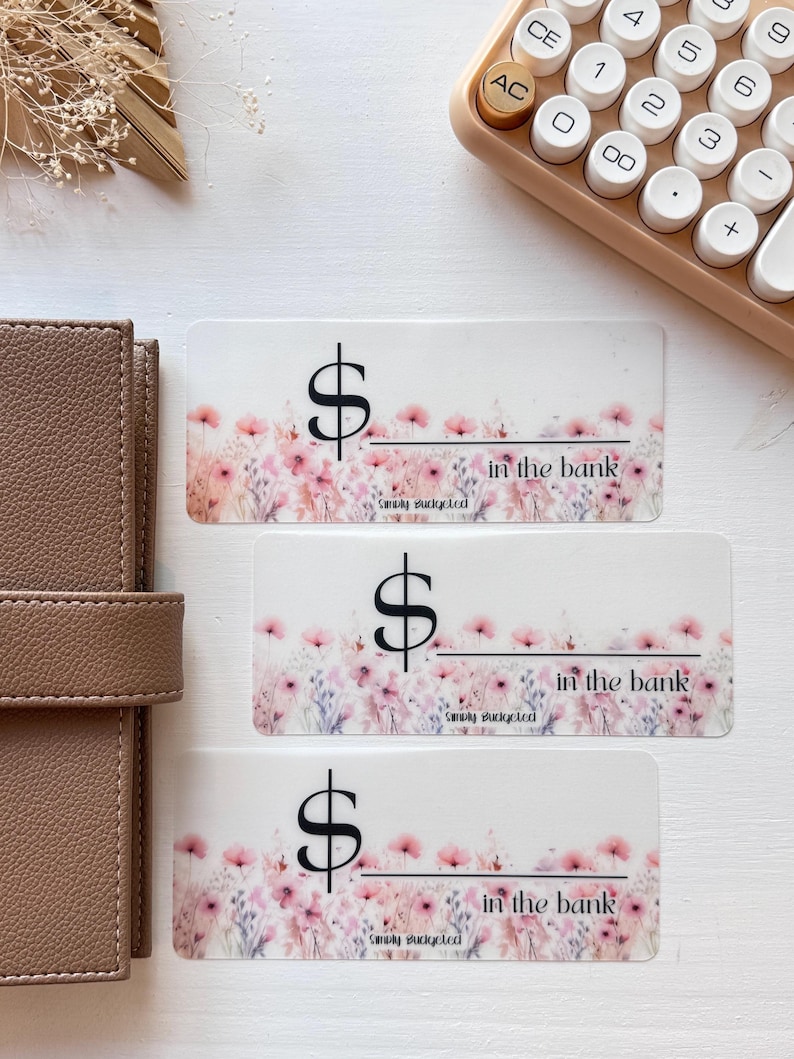 May include: Three floral patterned stickers with a dollar sign and the text "in the bank" and "Simply Budgeted".