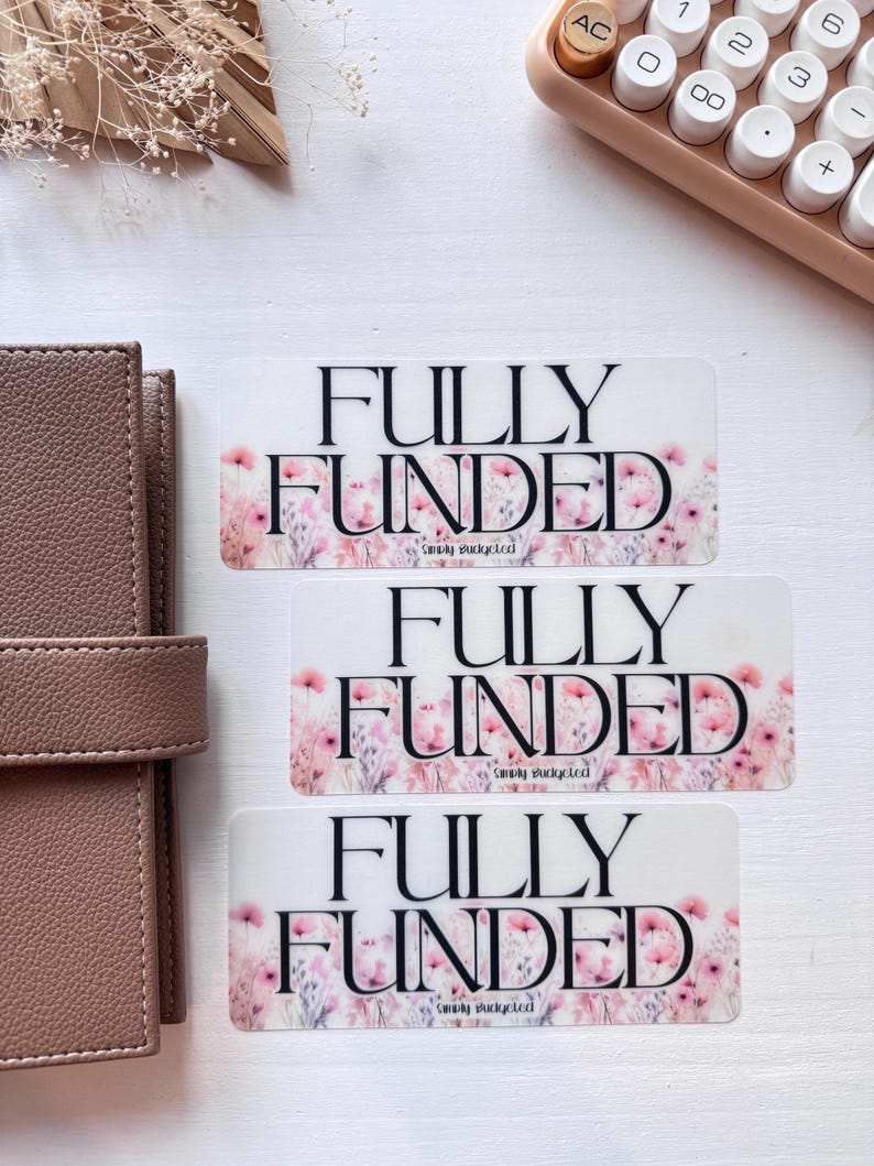 May include: Three white stickers with pink floral designs and the text "FULLY FUNDED" in black. The text "Simply Budgeted" is also included on each sticker.