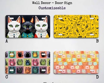 Puede incluir: Placas de matrícula de aluminio, 30.5 cm x 15.2 cm, con varios diseños de gatos. Las opciones incluyen un trío de gatos con ojos verdes, una placa amarilla con siluetas de gatos, una cuadrícula colorida de gatos y una placa con caras de gatos. El texto "License Plate" es visible.