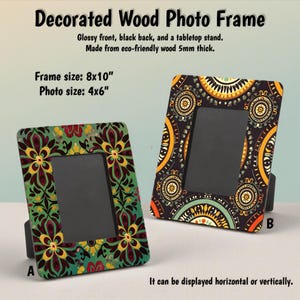 Puede incluir: Dos marcos de fotos de madera decorados con frentes brillantes y respaldos negros. El tamaño del marco es de 20,3x25,4 cm, el tamaño de la foto es de 10,2x15,2 cm. Un marco tiene un diseño floral verde, el otro tiene un patrón negro, amarillo y naranja. Los marcos se pueden mostrar horizontal o verticalmente.