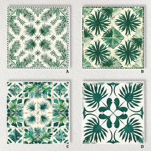 May include: Four square ceramic tiles with green botanical designs on a cream background. The tiles feature various patterns of stylized leaves and floral elements, creating a cohesive tropical theme. Each tile showcases a unique arrangement of the foliage.