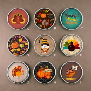 May include: Nine round decorative magnets with Thanksgiving-themed designs. The designs include turkeys, pumpkins, fall leaves, and a gnome. Some magnets have the phrases "thankful & blessed" and "Give Thanks".