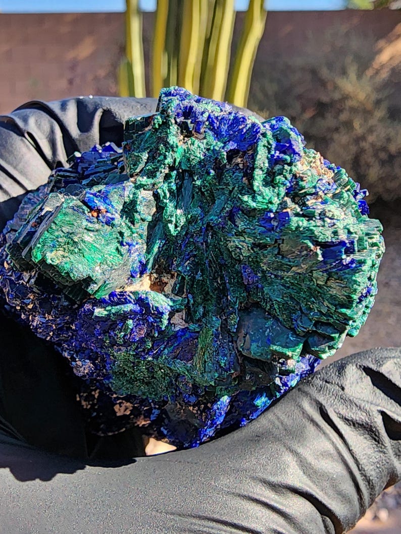 May include: A cluster of blue azurite and green malachite crystals. The crystals are rough and have a natural, unpolished look.