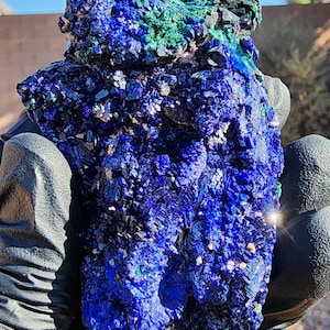 May include: A large, rough, blue and green azurite and malachite specimen. The azurite is a deep blue color and the malachite is a bright green color. The specimen is very detailed and has a lot of texture.