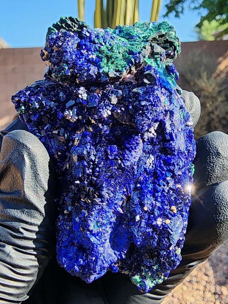 May include: A large, rough, blue and green azurite and malachite specimen. The azurite is a deep blue color and the malachite is a bright green color. The specimen is very detailed and has a lot of texture.