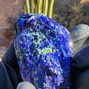 May include: A large, rough, blue and green azurite crystal with a sparkly, iridescent surface.