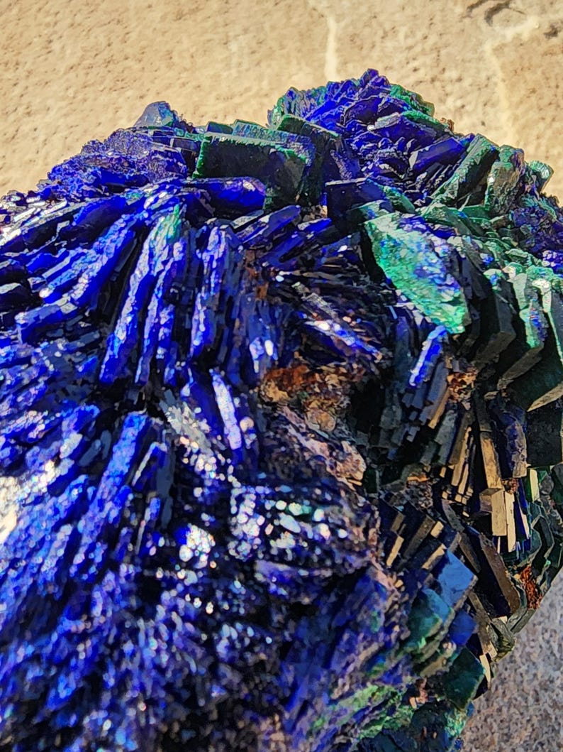 May include: Azurite and malachite crystal cluster with a deep blue and green color. The crystal has a rough, natural texture and is a beautiful example of these minerals.