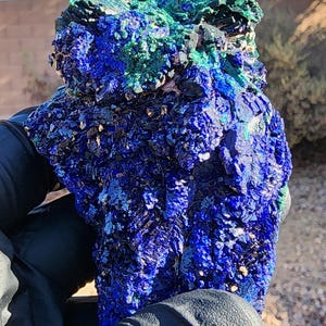 May include: A large, rough, blue and green azurite and malachite specimen. The azurite is a deep blue color and the malachite is a bright green color. The specimen is very detailed and has a lot of texture.