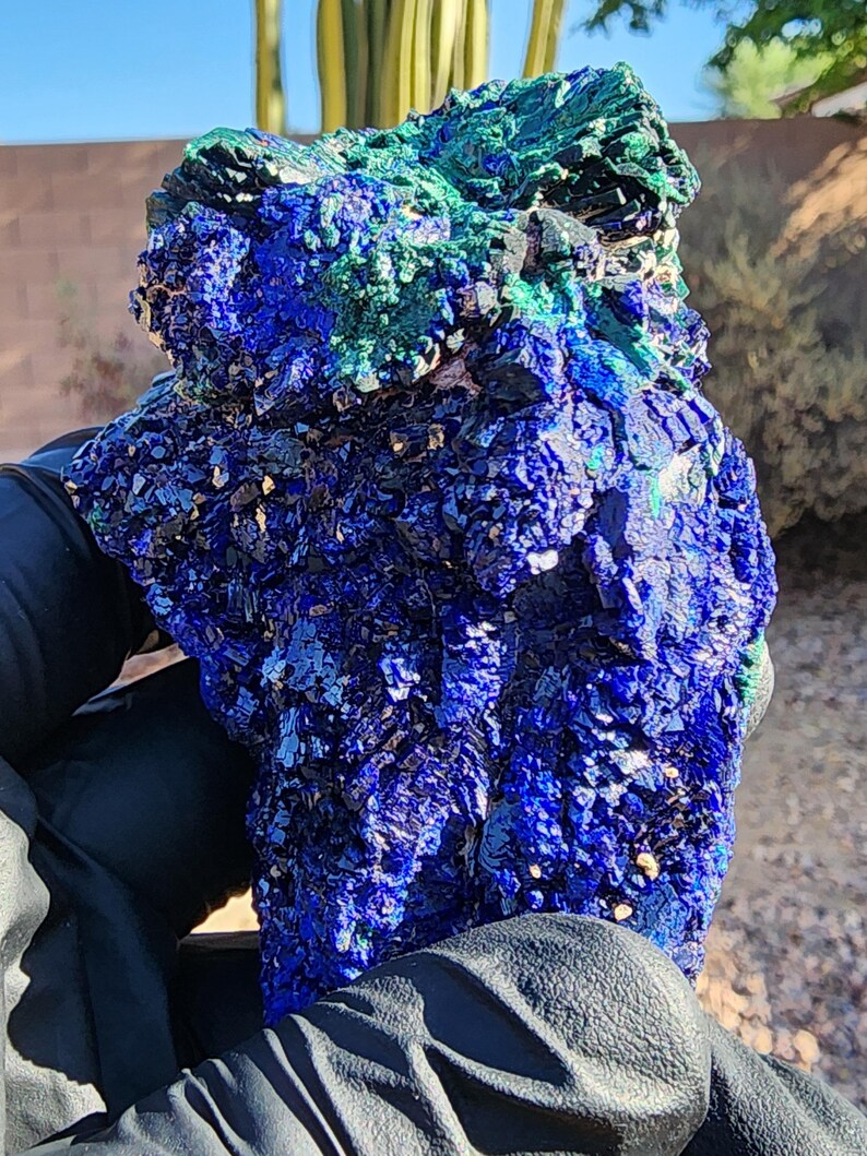 May include: A large, rough, blue and green azurite and malachite specimen. The azurite is a deep blue color and the malachite is a bright green color. The specimen is very detailed and has a lot of texture.