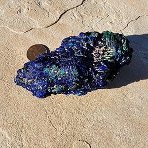 May include: Azurite and malachite crystal cluster with a blue and green color pattern. The crystal is about the size of a U.S. quarter.