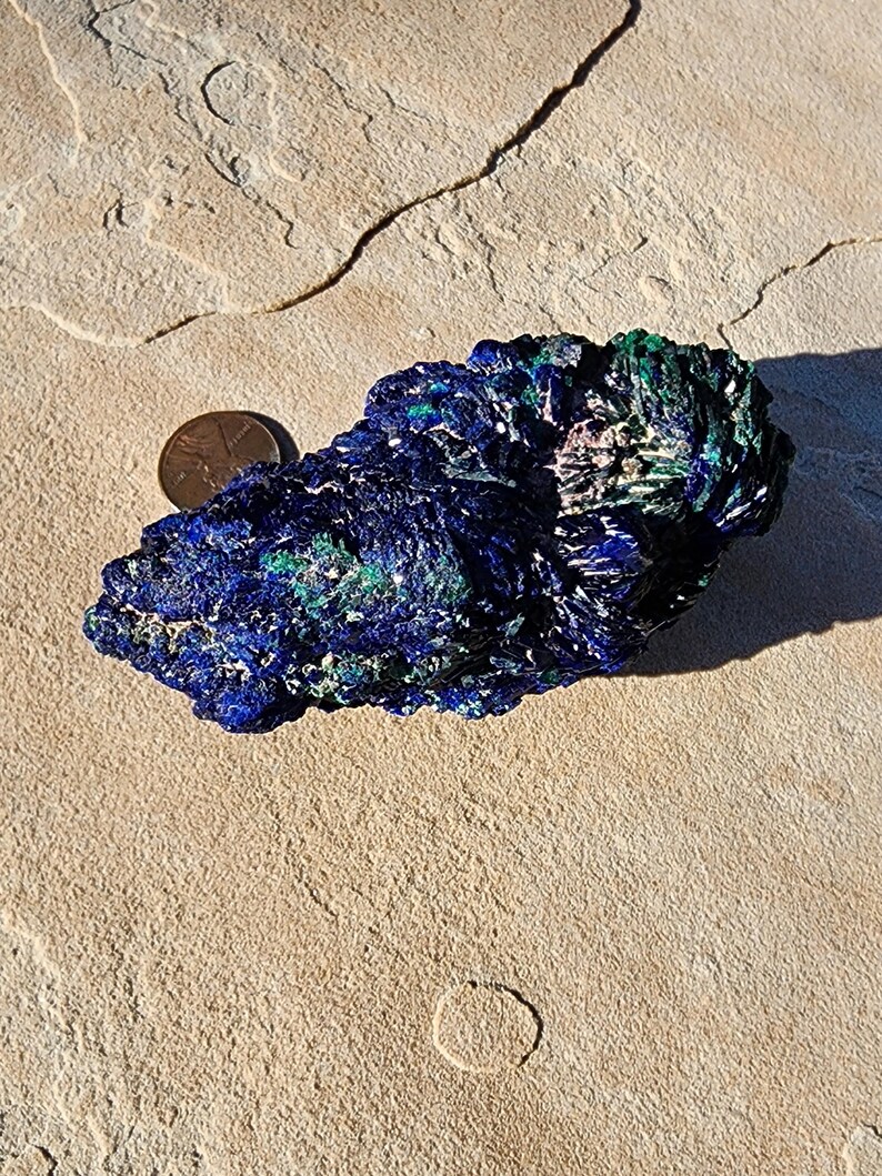 May include: Azurite and malachite crystal cluster with a blue and green color pattern. The crystal is about the size of a U.S. quarter.