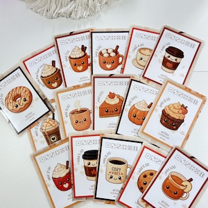 May include: A collection of rectangular cards featuring cute, illustrated food and drink items with smiling faces. Each card displays a dice pattern, a numerical value, and the text 90 DAYS LOCKED IN. The illustrations include coffee cups, a doughnut, a pumpkin, a cupcake, and a slice of pie in warm, autumnal colours.