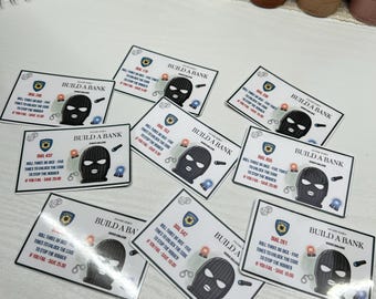 May include: A collection of Build a Bank game cards featuring a black ski mask graphic. Each card has a unique dial number and instructions to unlock a code. The cards are white with black and blue accents.