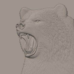Puede incluir: Una escultura en relieve monocrom&aacute;tica y tridimensional de una cabeza de oso de perfil. El oso se muestra con la boca muy abierta, revelando dientes afilados y una lengua texturizada. La superficie presenta detalles de pelaje en tono gris.