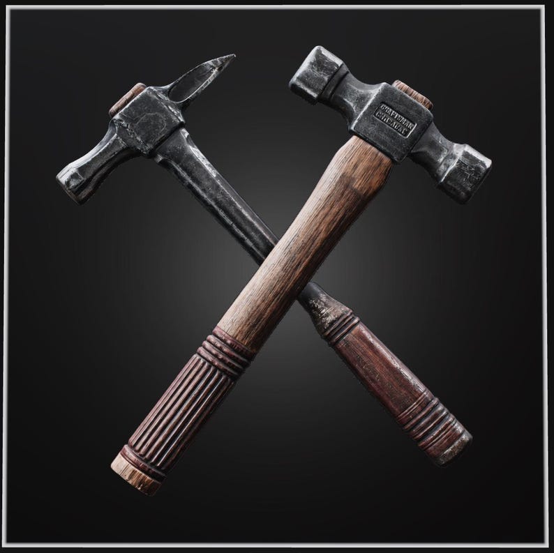 May include: Two crossed hammers with dark metal heads and wooden handles. The hammer on the right features a double-sided head with the text Craftsman stamped on the metal. The hammer on the left has a pointed claw and a smooth, dark metal finish.