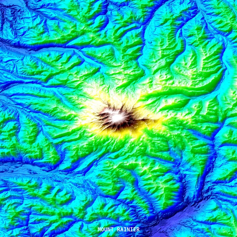 May include: A colorful topographic map of Mount Rainier, with vibrant shades of blue, green, yellow, and brown. The text "MOUNT RAINIER" is at the bottom. The map shows the mountain's elevation and surrounding terrain.