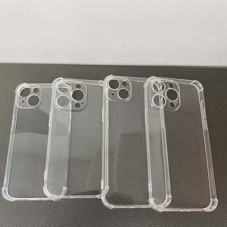 May include: Four clear plastic phone cases for an iPhone. The cases are all the same design, with a raised lip around the camera lens and a slightly textured finish.