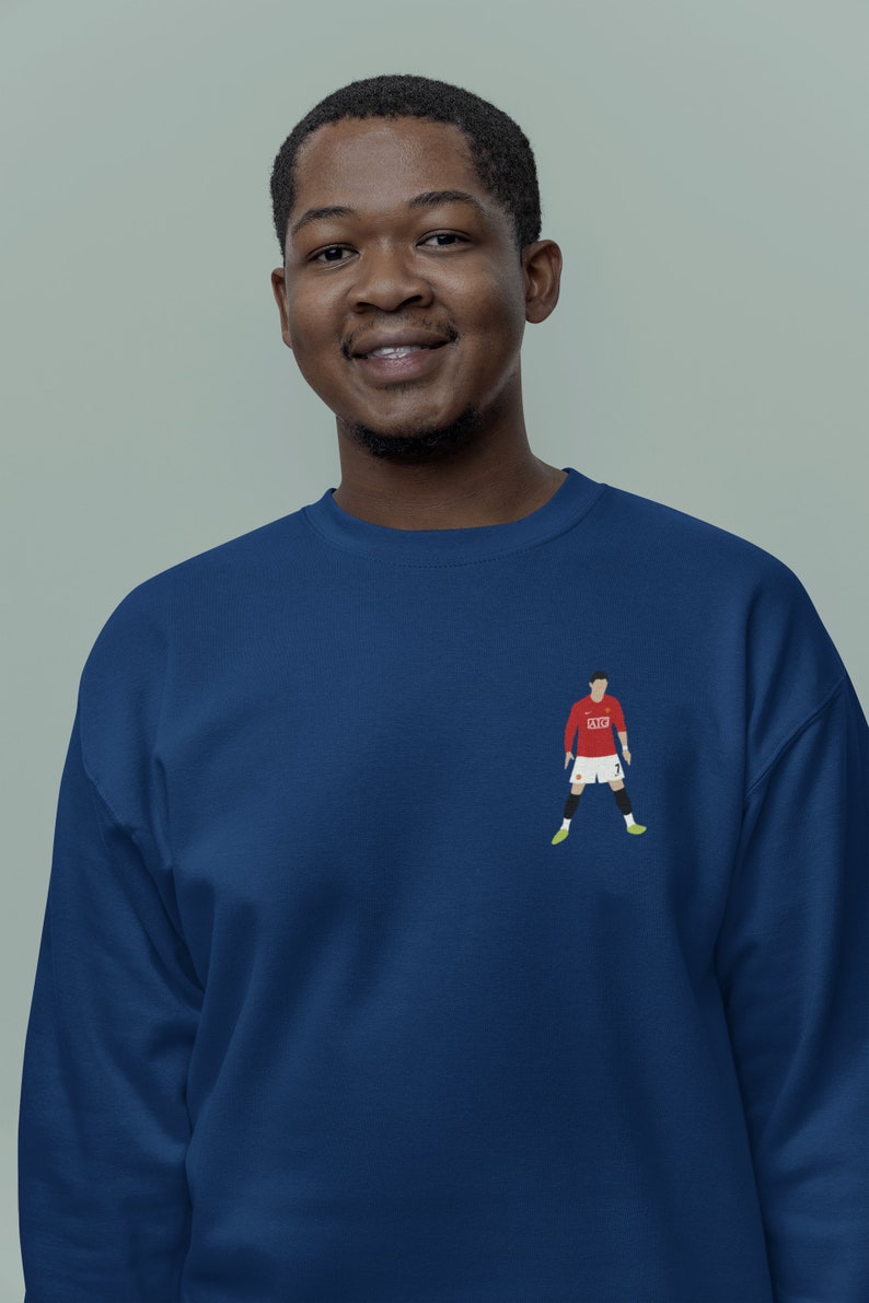 May include: A navy blue sweatshirt with a red and white soccer player graphic on the front. The player is wearing a red jersey with the number 7 on it.