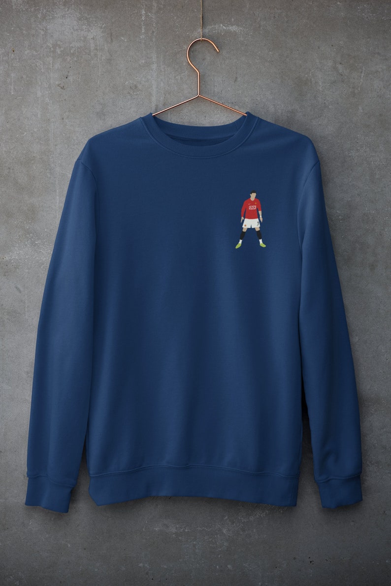 May include: A navy blue sweatshirt with a small embroidered image of a soccer player wearing a red jersey with the number "7" on it.