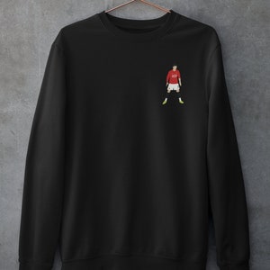 May include: Black sweatshirt with a small embroidered image of a soccer player wearing a red jersey with the number 7 on it.