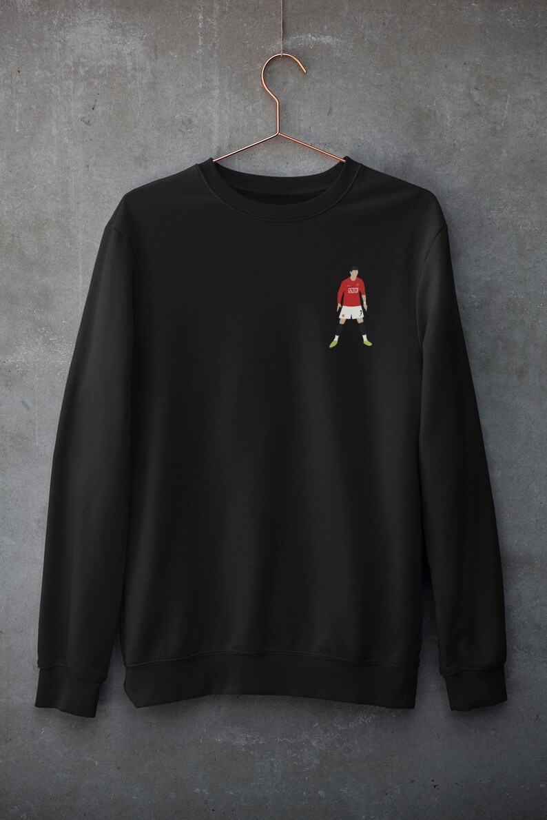 May include: Black sweatshirt with a small embroidered image of a soccer player wearing a red jersey with the number 7 on it.