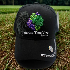 May include: Black baseball cap with embroidered grape and leaf design. Text on the cap reads "I am the True Vine" and "My Father is the Vinedresser."