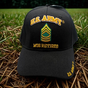 Puede incluir: Gorra de béisbol negra con texto e insignia bordados. La gorra presenta "U.S. ARMY" en letras doradas sobre una insignia verde y dorada, con "MSG RETIRED" debajo. La visera tiene "U.S. ARMY" en dorado.