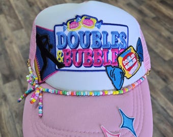 Pink Doubles & Bubbles softball hat with player silhouette and beaded hat chain.