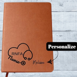 May include: A brown leather journal with a black stethoscope and heart design. The text "RNFA Nurse" and "Melissa" are engraved on the front cover.