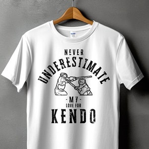 May include: White t-shirt with a black graphic print that says "Never Underestimate - M7 - Love for Kendo". The graphic also features two figures in a kendo match.