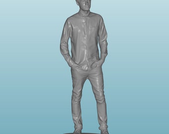 May include: A gray 3D printed figurine of a person standing with their hands in their pockets, wearing a button-down shirt and jeans.