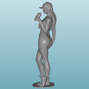 May include: A gray figurine of a person wearing a baseball cap, headphones, and a crop top. The person is holding a cup and is standing on a base.