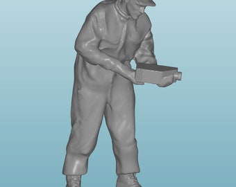 May include: A gray figurine of a person wearing a cap and overalls, holding a rectangular object in their hands.