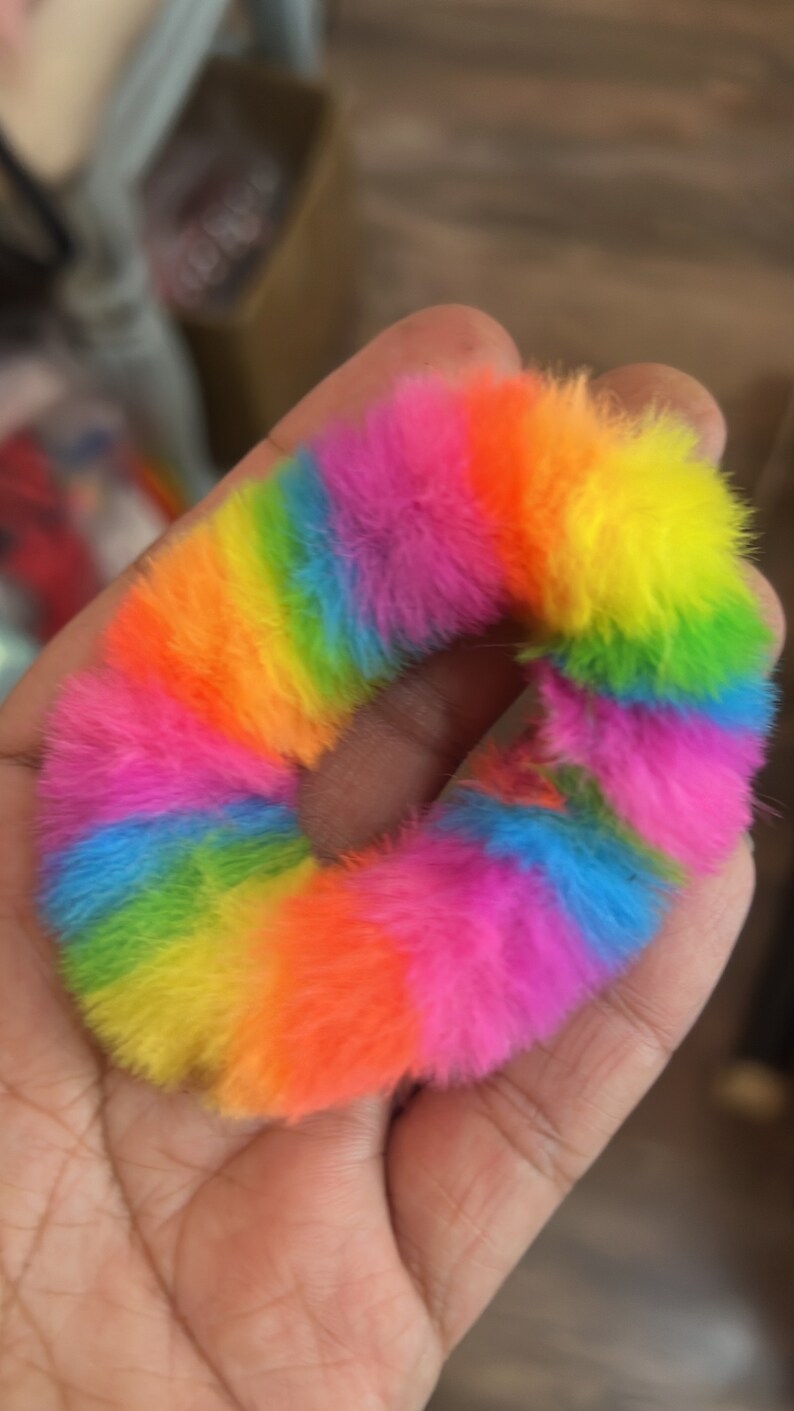 May include: A rainbow colored fuzzy hair scrunchie.
