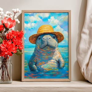 May include: A framed art print of a manatee wearing a straw hat, set in blue water under a cloudy sky. The manatee is painted in vibrant colors, with a focus on its face and the hat. The artwork is displayed on a wooden surface.