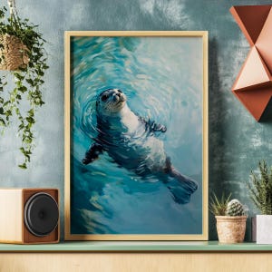May include: A framed painting of a seal swimming in blue water. The seal is gray and white with black eyes and a black nose. The water is rippling around the seal.